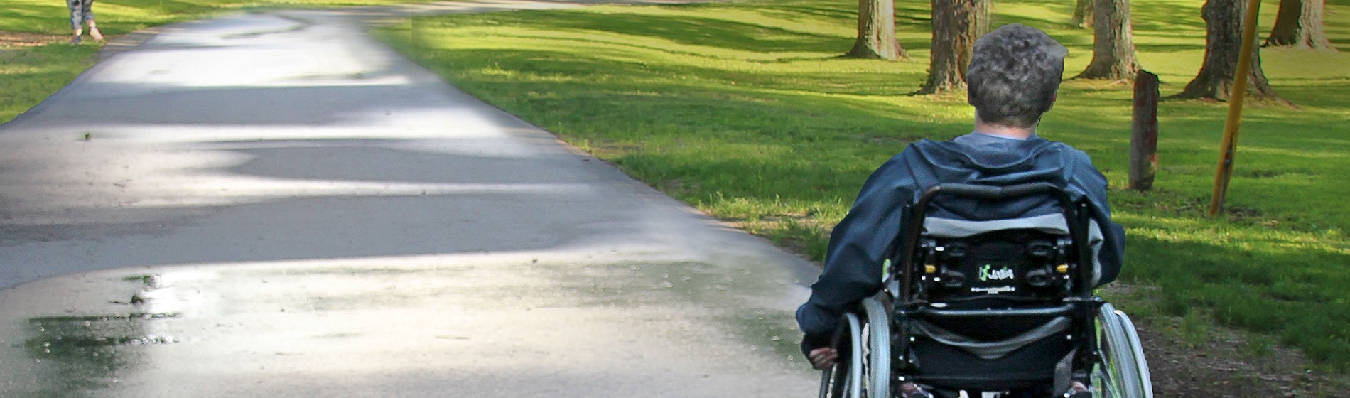 lad rolling through Elgin Park in wheelchair